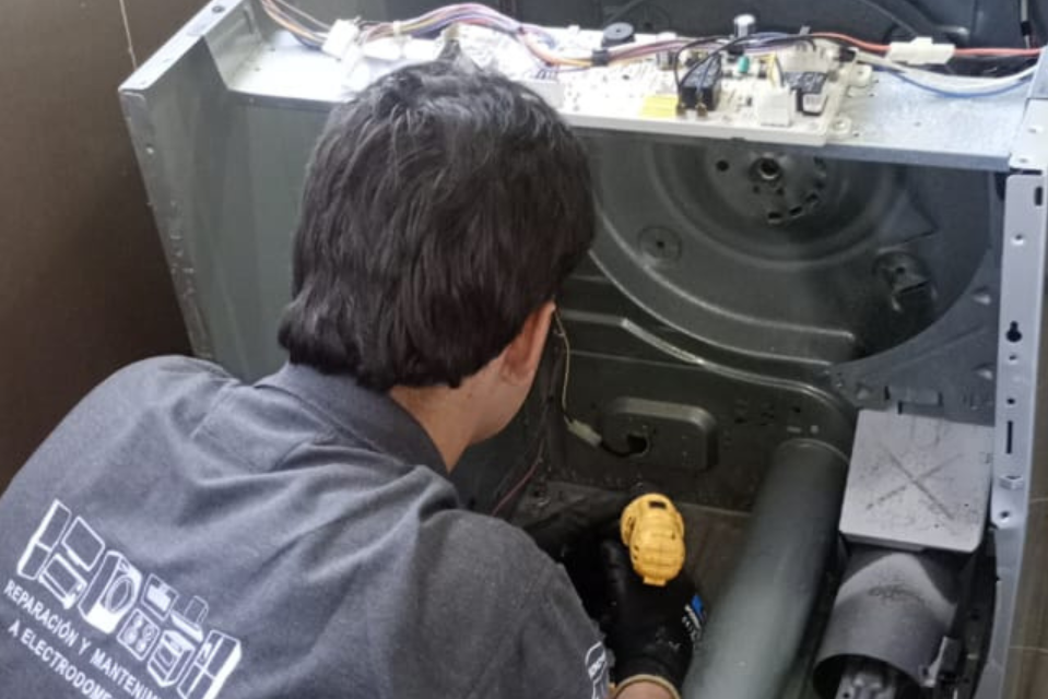 Técnico reparando secadora de ropa